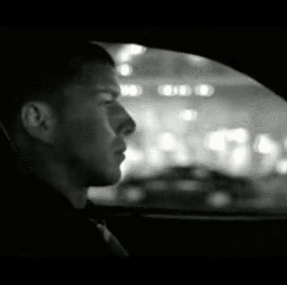 passenger view of man driving car in black and white